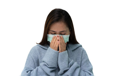 Portrait of woman covering face against white background