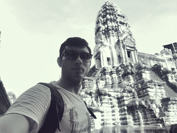 Portrait of young man wearing sunglasses against sky