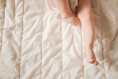 Soft focus close-up of newborn baby feet on a white blanket.