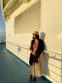 Smiling woman wearing sunglasses looking away standing on boat deck