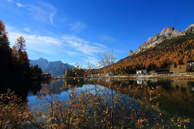 Scenic view of lake and mountains against blue sky