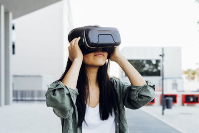 Young woman with black hair wearing virtual reality simulator