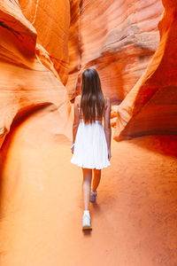 Full length rear view of woman walking on rock