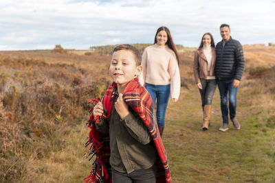 Full length portrait of friends standing on land