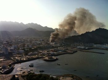 High angle view of smoke emitting from city against sky