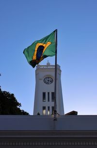 Low angle view of flag against clear blue sky