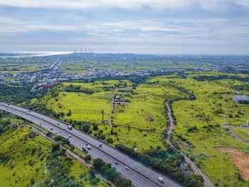 High angle view of road amidst field against sky