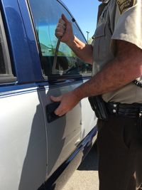 Midsection of man driving car against sky