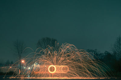 Illuminated wire wool against sky at night