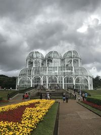 Group of people in front of built structure against cloudy sky