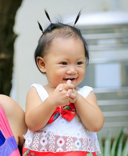 Cute baby girl with pigtails looking away outdoors