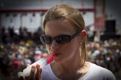 Close-up of woman drinking jello shot from syringe