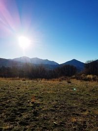 Scenic view of field and mountains against sky