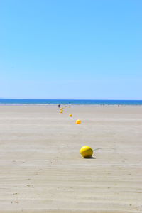 Scenic view of beach against clear blue sky