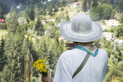 Rear view of man wearing hat looking at trees