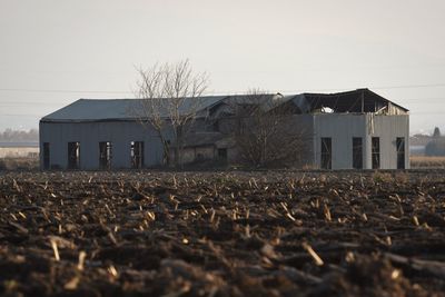 Abandoned house on field against clear sky