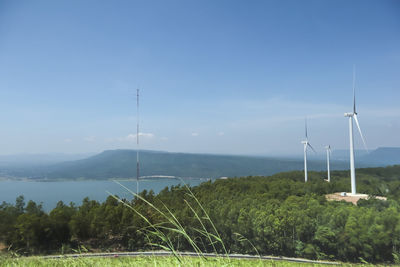 Wind turbines on land against sky