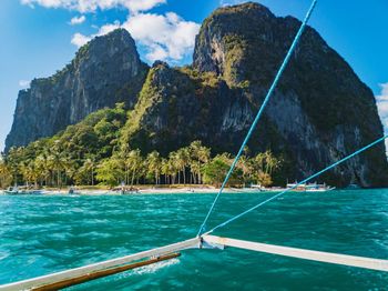 Scenic view of sea by mountains against sky