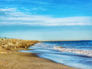 Scenic view of beach against blue sky