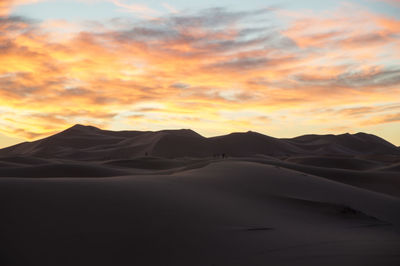 Scenic view of desert against sky during sunset