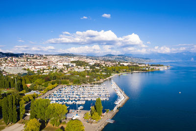 High angle view of townscape by sea against sky