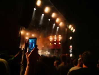 Cropped hand photographing with smart phone during music concert