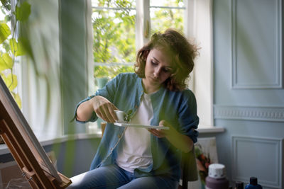 Artist squeezing paint on palette