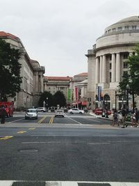 Cars on road against buildings in city