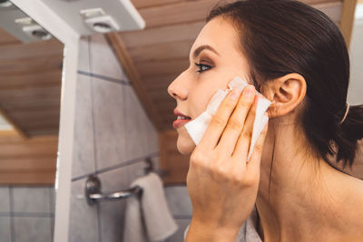 Side view of a young woman using mobile phone