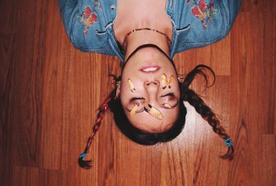 Low section of woman lying on hardwood floor