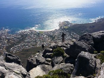 Aerial view of people standing at table mountain against sea on sunny day