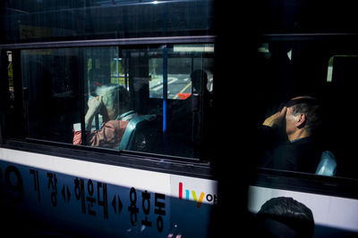 People traveling in bus seen through window