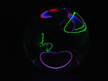 Close-up of illuminated lighting equipment against black background