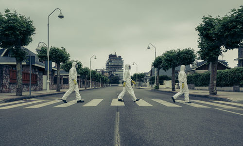 Man and women walking on crosswalk against sky