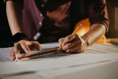 Midsection of man working on cutting board