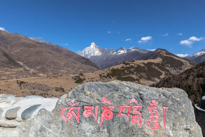 Text written on mountain against sky