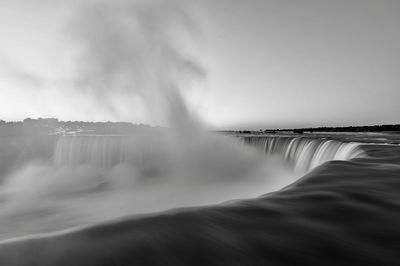 Scenic view of waterfall against sky