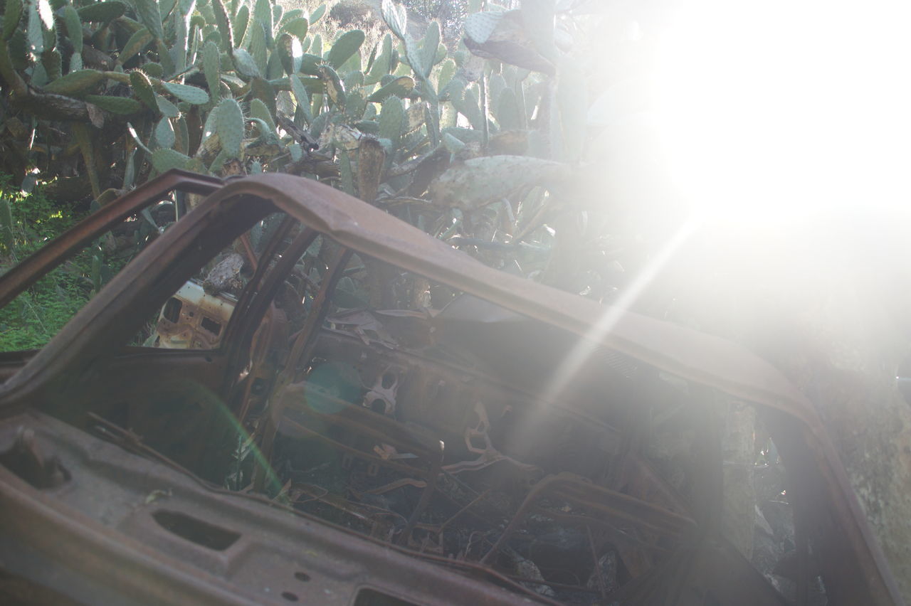 CLOSE-UP OF ABANDONED CAR AGAINST SKY