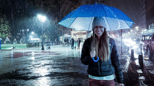 Portrait of smiling woman in snow at night