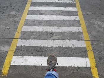 Low section of man walking on road