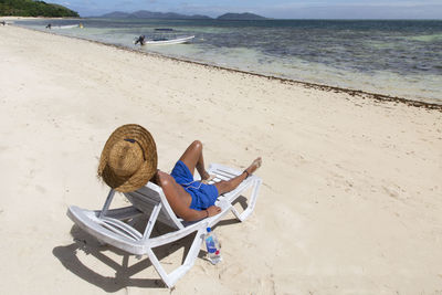 Man sitting on chair at beach