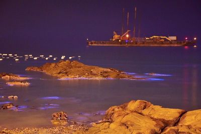 Panoramic view of illuminated sea against sky at night