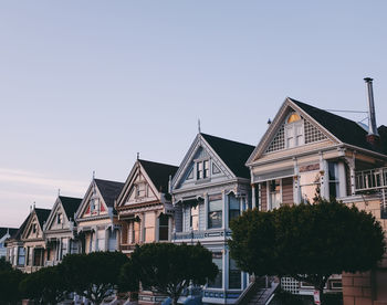 Low angle view of buildings against clear sky during sunset