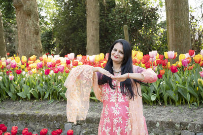 A beautiful indian woman with black hair in a national indian pink sari dress