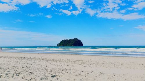 Scenic view of beach against blue sky