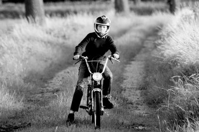 Portrait of boy riding bicycle on field