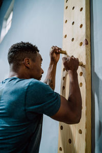 Low angle view of man climbing wall