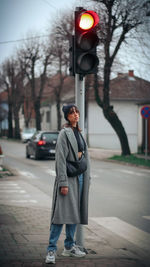 Full length portrait of man standing on street in city