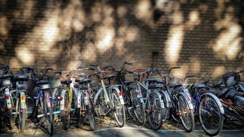 Bicycles parked at parking lot against brick wall