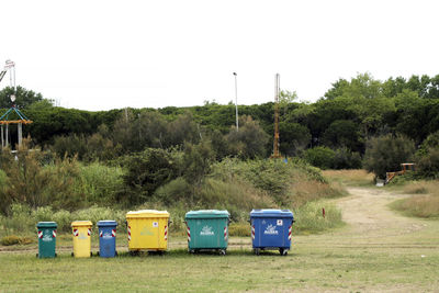 Garbage bin on field against clear sky